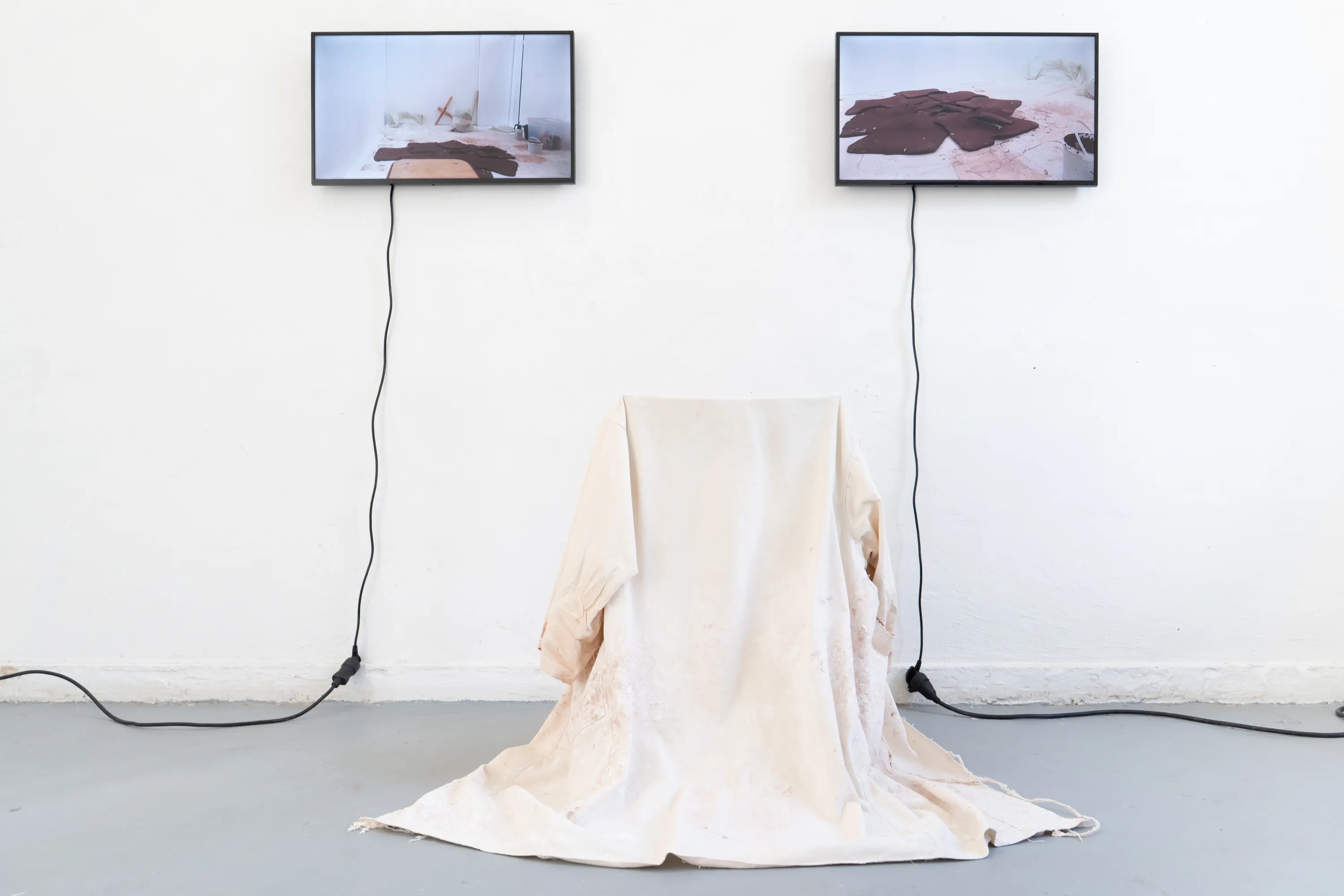 Elle est nue sous ses cheveux, 2026. argile rouge crue, coques de grillage et plâtre, diffusion sonore, costume d'enfant. Photo © Margot Anquez-Bariseau